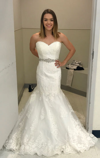 Gabi Settles stands outside a dressing room  during the 2018 Goodwill Gown Sale, showing off the $1,000 gown she purchased for $89.