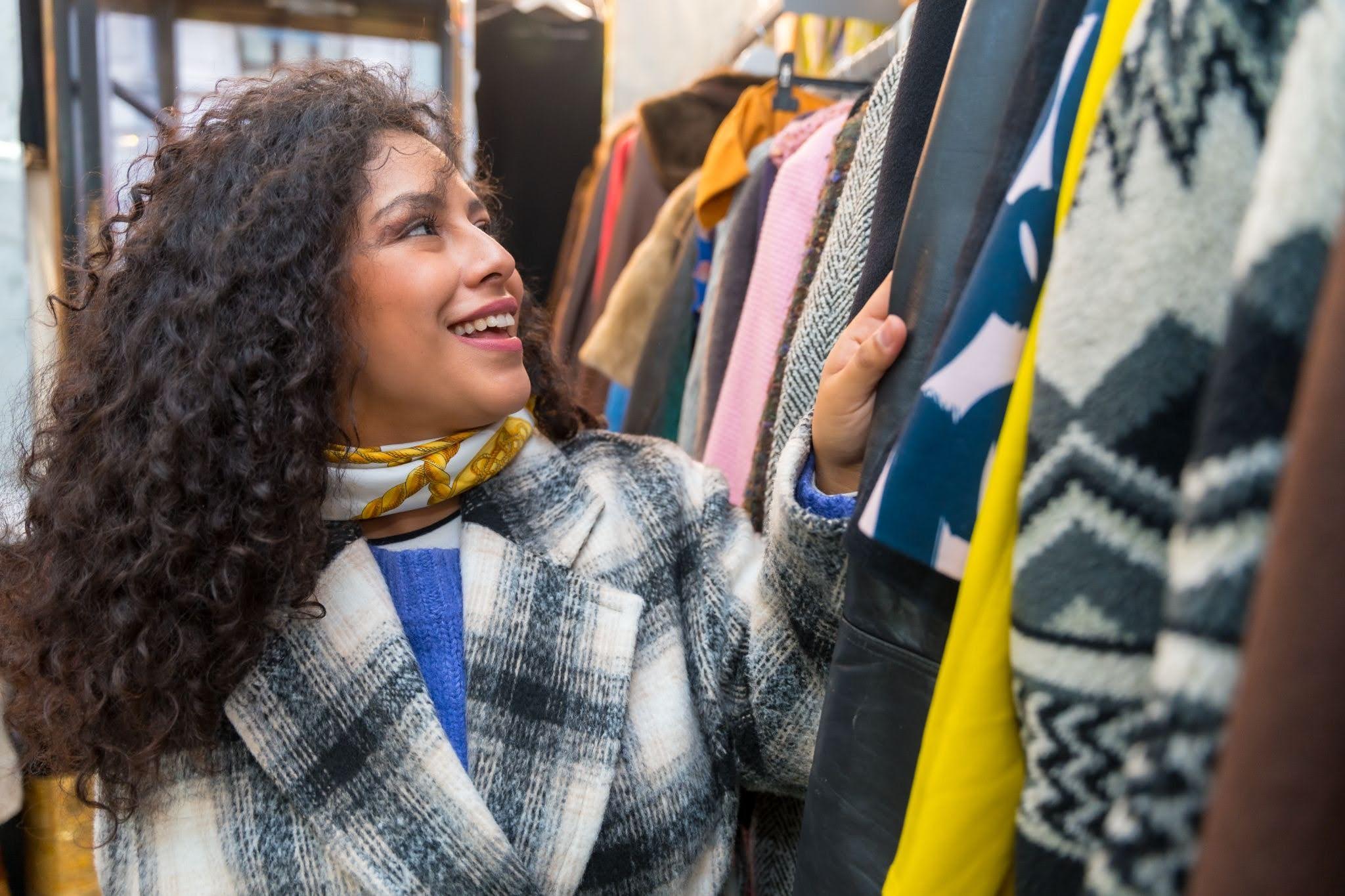Young woman thrifting for vintage clothes at Goodwill