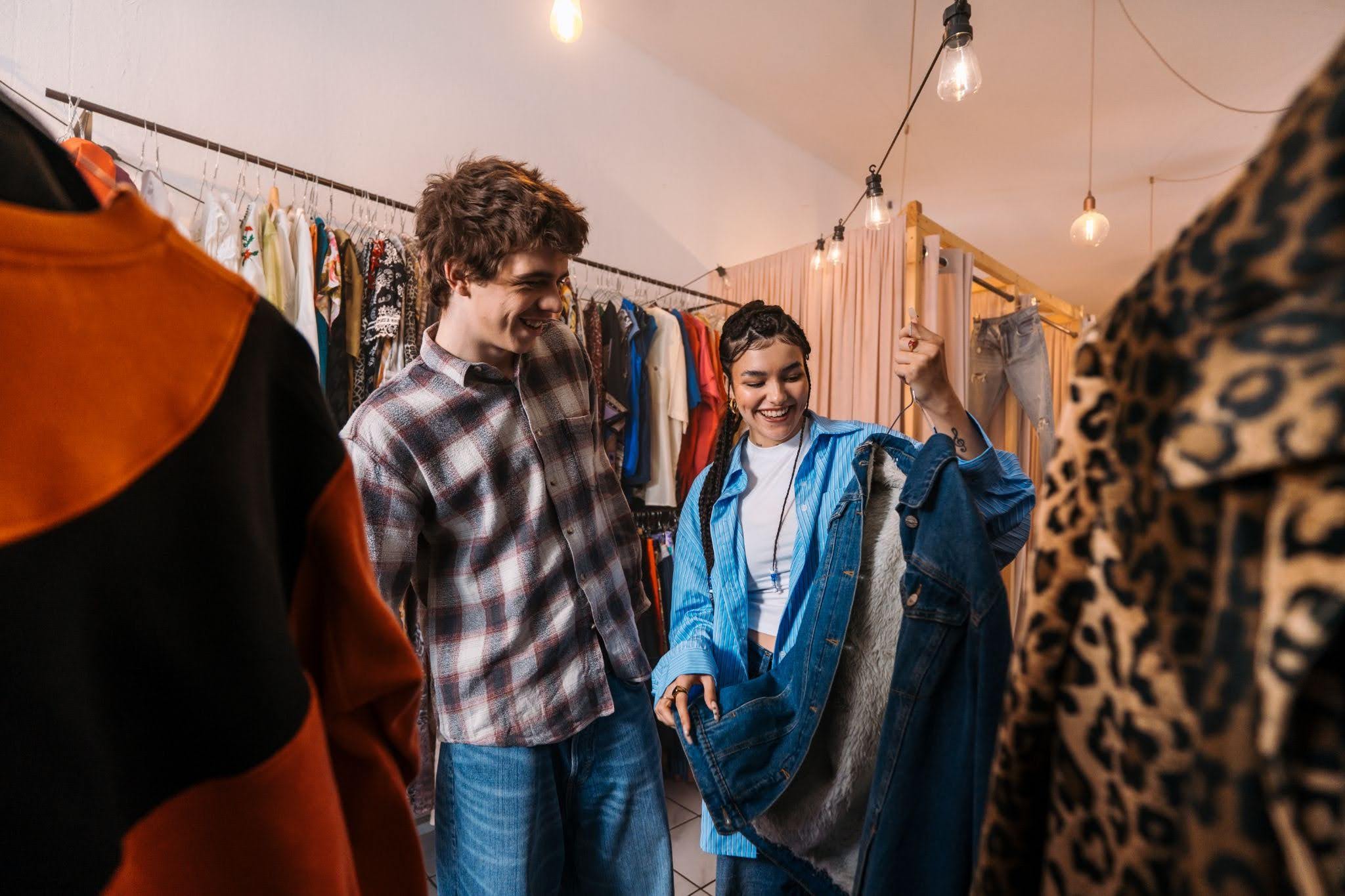 Young friends having fun during thrift store scavenger hunt